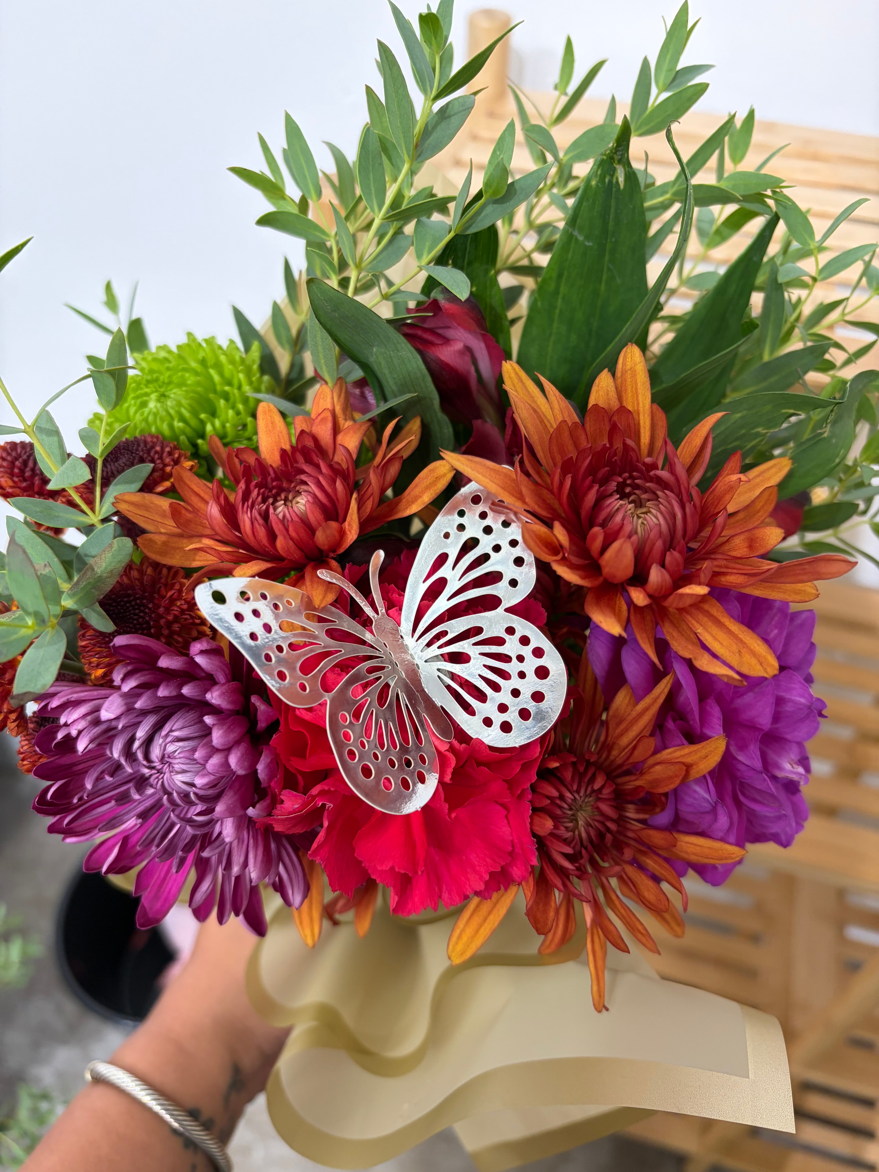 Vibrant chrysanthemum bouquet with silver butterfly decorations