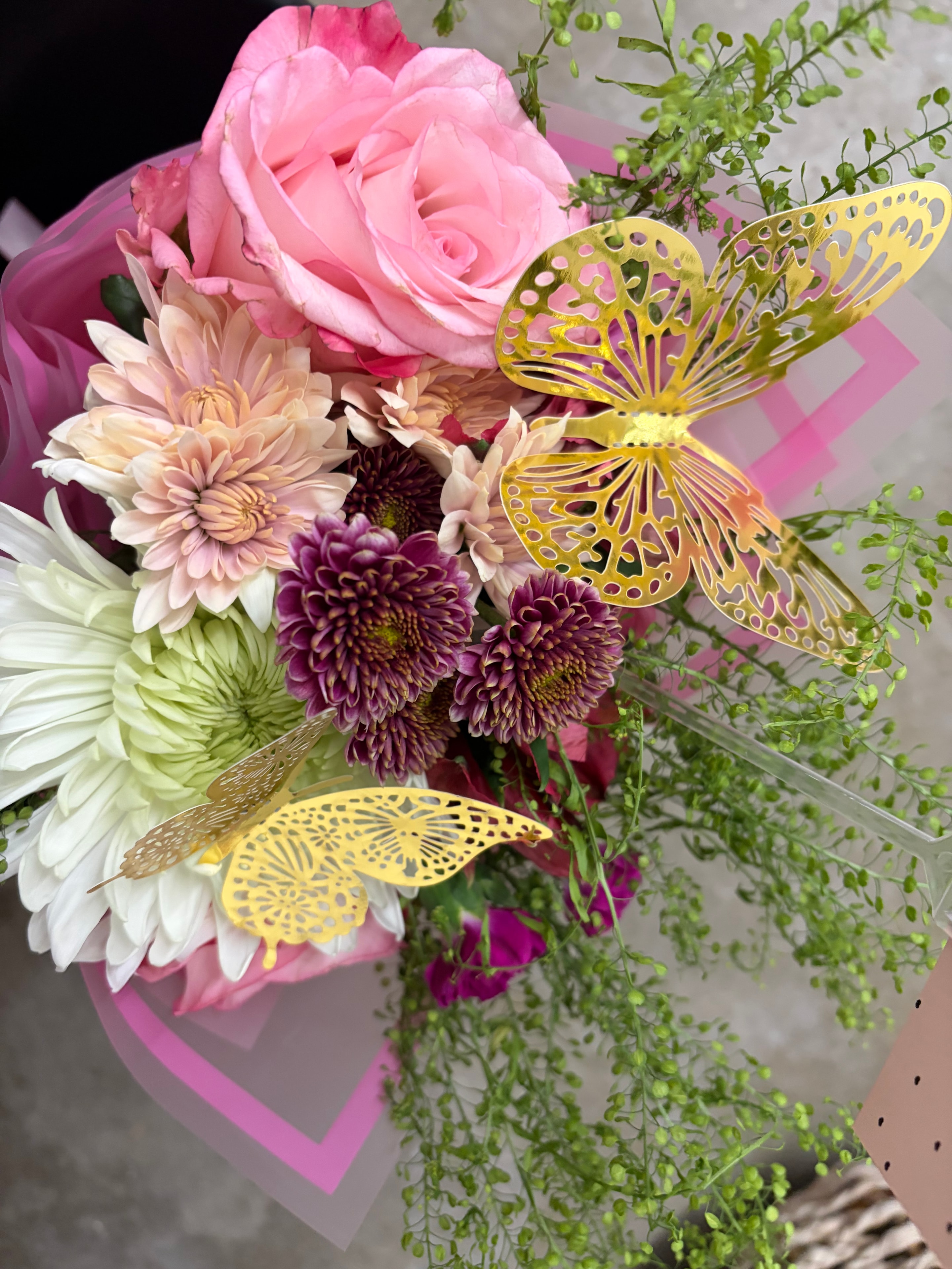 Small pastel flower bouquet wrapped in translucent paper